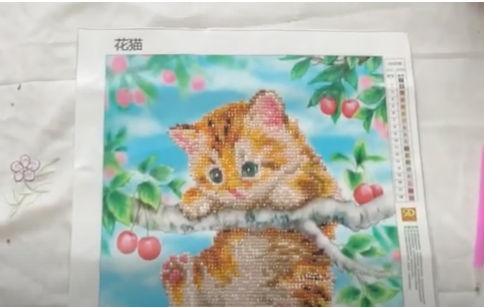 gatito hecho en punto diamante colgado de una rama
