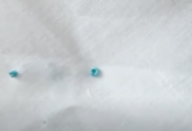 imagen de un nudo francés realizado con hilo azul sobre tela de algodón blanca