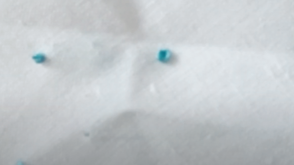 imagen de un nudo francés realizado con hilo azul sobre tela de algodón blanca
