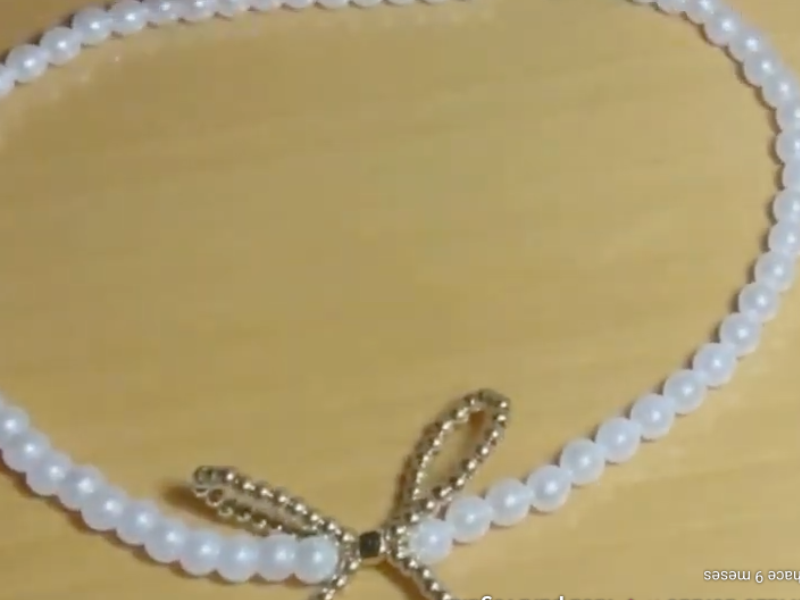 collar de perlas con lazo sobre la mesa