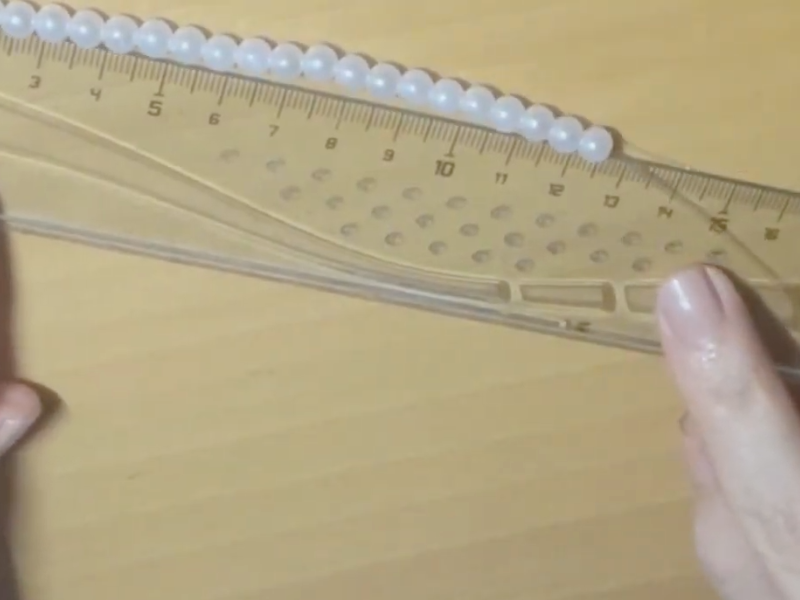 se colocan las perlas en la otra mitad del collar
