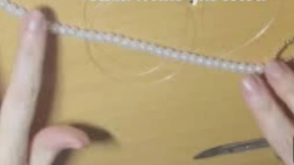 collar de perlas blancas con lazo dorado